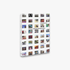 Book titled 'In the Moment: 40 Years of Reuters Photojournalism' with collage of photos on a white background