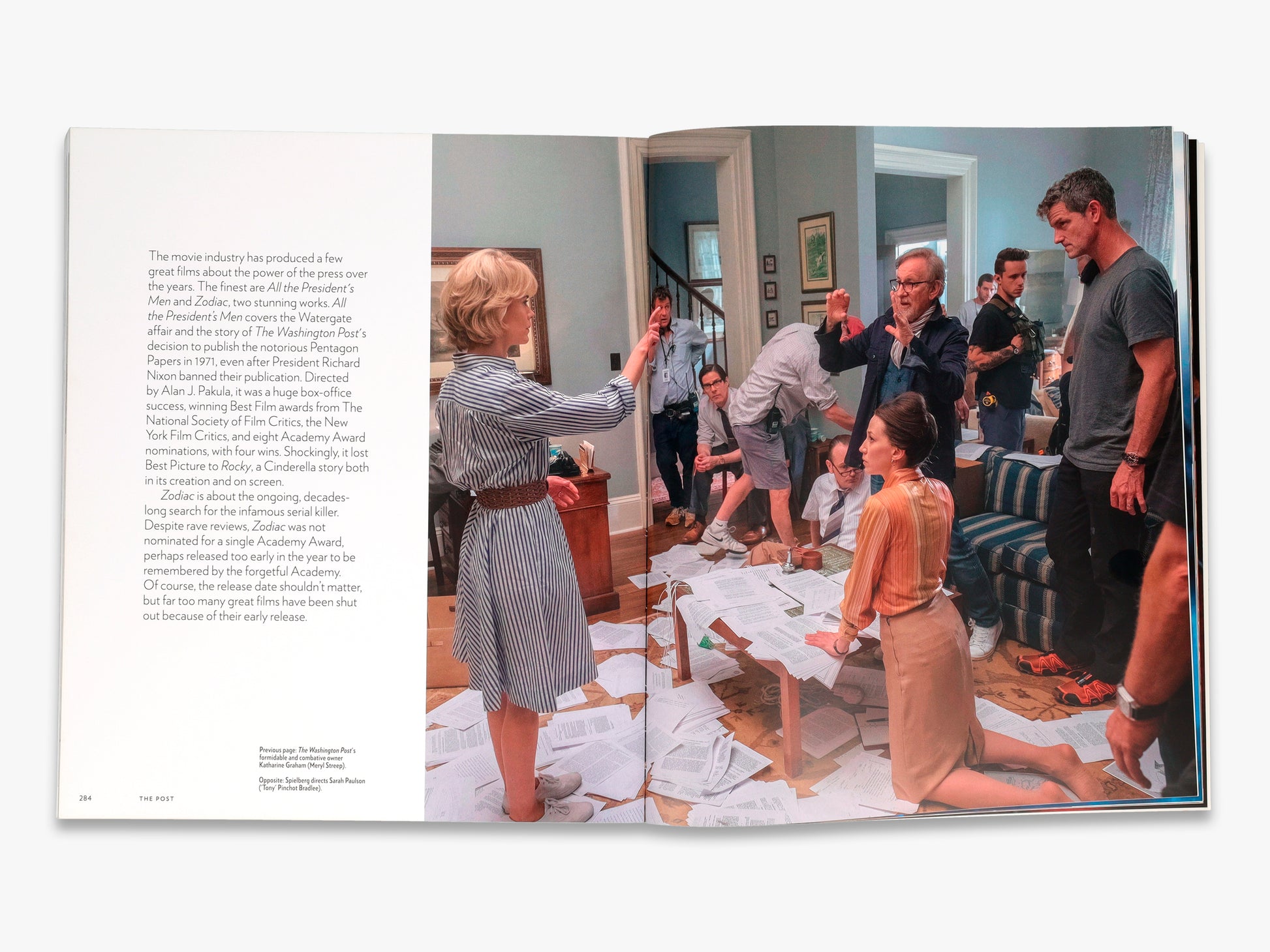 Open book showing a scene with people in a room, likely from a magazine or book.