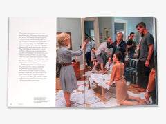 Open book showing a scene with people in a room, likely from a magazine or book.