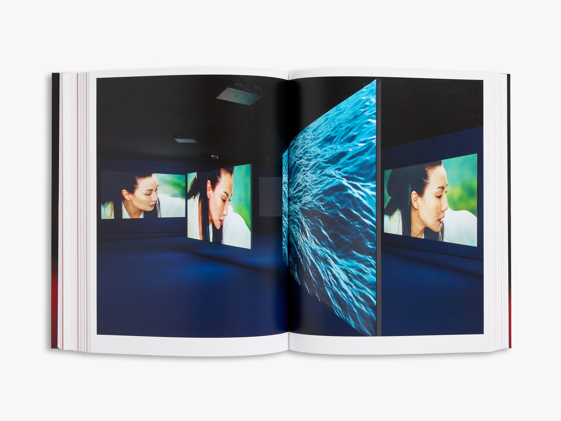 Open book showing a multimedia display with images of people and abstract blue patterns.