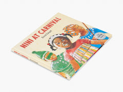 Book titled 'Nini at Carnival' with colorful illustrations on a white background